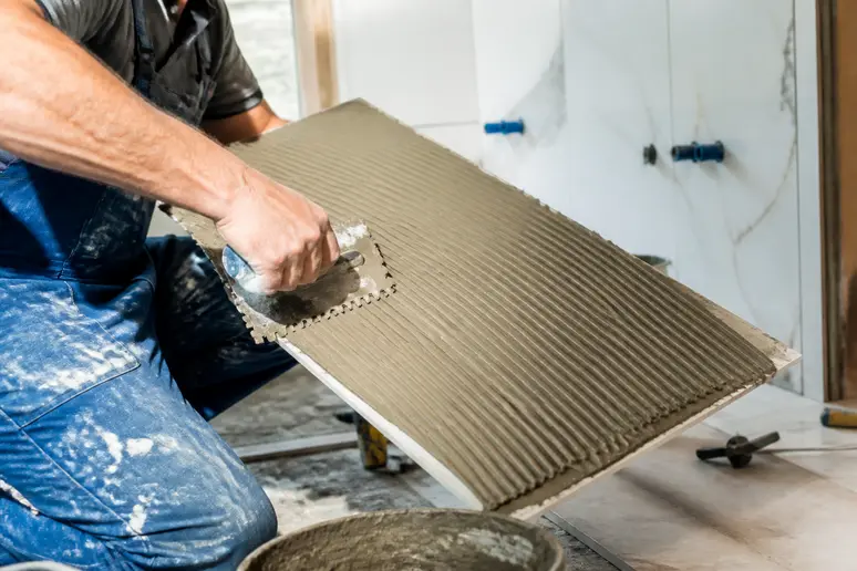 Encollage double d'un grand carrelage de sol par un carreleur professionnel