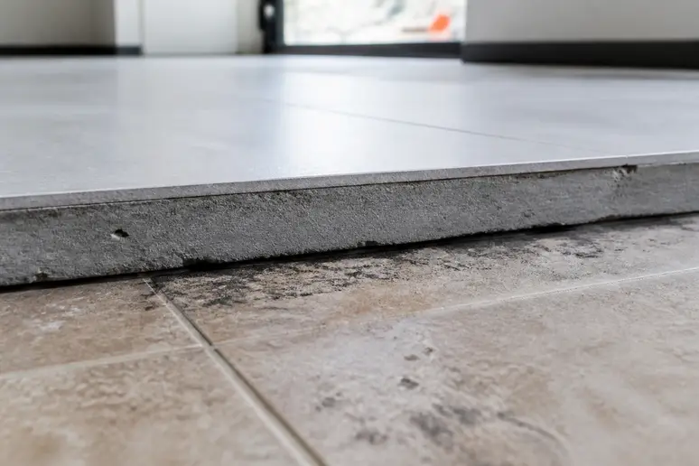 Visualisation de la surépaisseur lors de coller du carrelage sur du carrelage existant au niveau d'une porte.