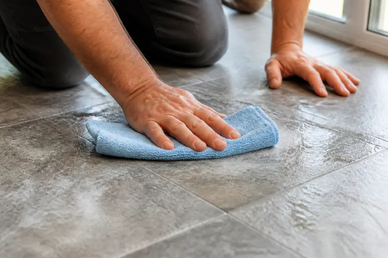 Nettoyage d'un carrelage texturé avec une bonnette microfibre en mouvement croisé.