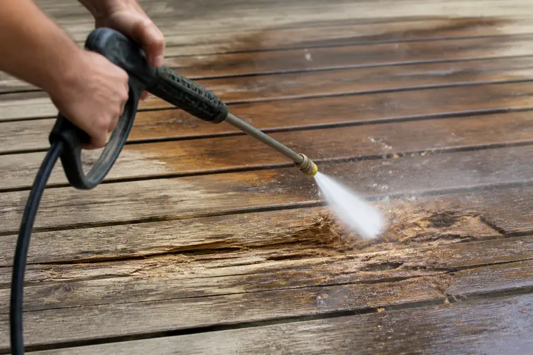 Nettoyeur haute pression endommageant des fibres de bois par un jet d'eau trop puissant, pour nettoyer une terrasse en bois.