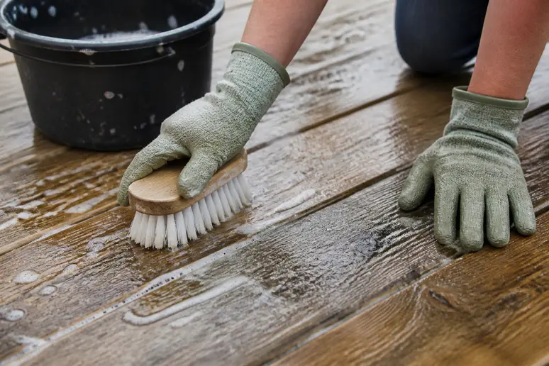 Nettoyer une terrasse en bois avec du savon noir et un balai-brosse pour un résultat impeccable.