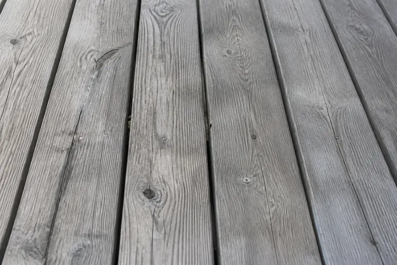 Aspect grisé et vieilli d'une lame de terrasse en bois, signe de l'oxydation à nettoyer.