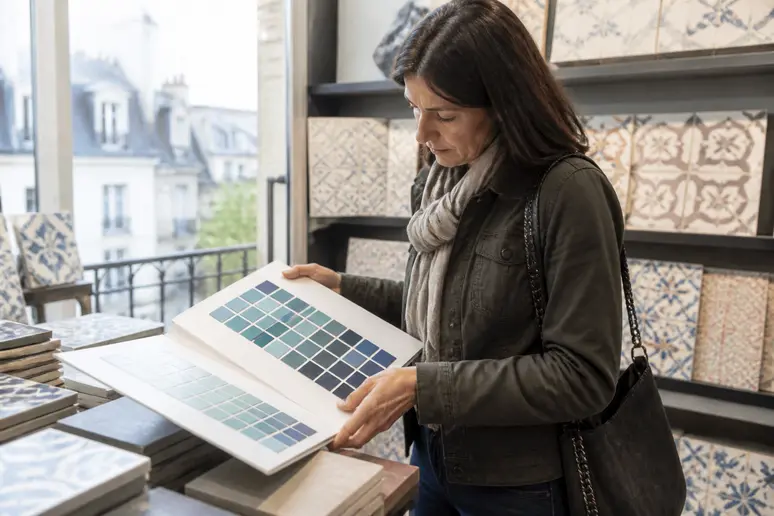 Une cliente examine un nuancier émaux de Briare dans un magasin spécialisé en France.