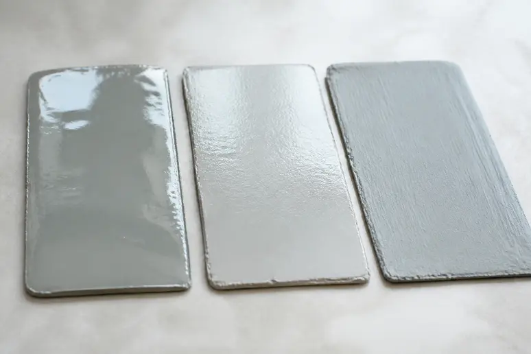Comparaison visuelle des finitions époxy, polyuréthane et acrylique pour peindre du carrelage mural.