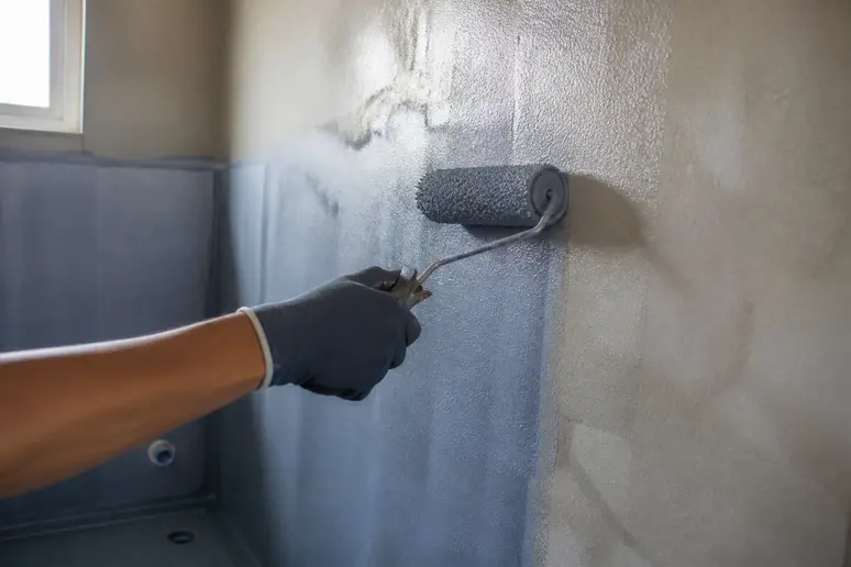Application d'un primaire d'étanchéité sur un mur pour préparer avant de poser du carrelage sur un mur.