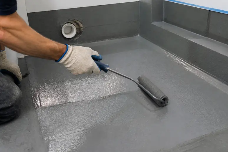 Application de protection à l'eau sous carrelage, aspect crucial du prix d'une pose de carrelage en milieu humide.