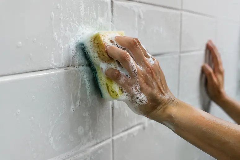 Nettoyage délicat d'un carrelage mural adhésif à l'eau savonneuse pour préserver la surface
