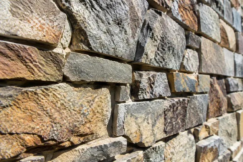 Gros plan sur un parement en pierre sculpté installé sur un mur extérieur