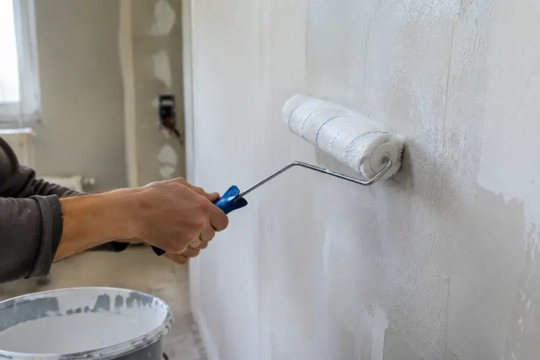 Application au rouleau d'un primaire d'accrochage sur le mur avant la pose du béton ciré