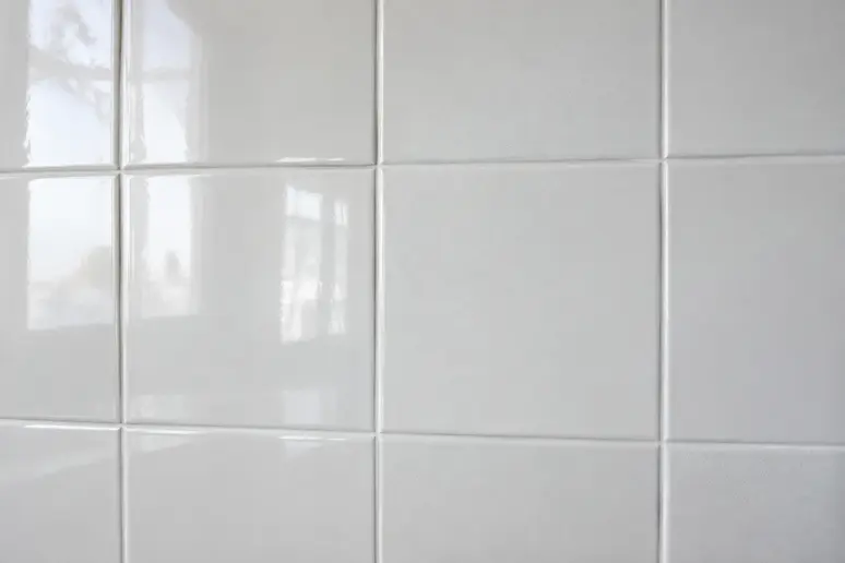 Carrelage mural blanc posé dans une salle de bain avec une finition mate et lumineuse