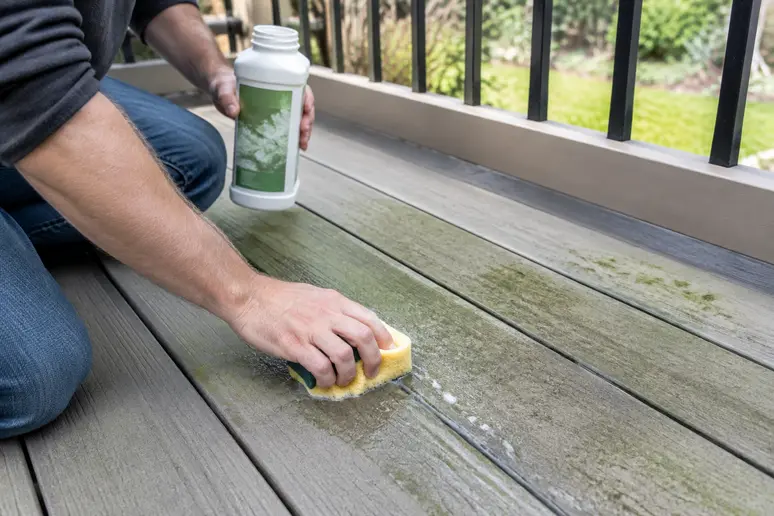 Application d'un produit nettoyant spécifique sur une tache verte d'une terrasse en composite