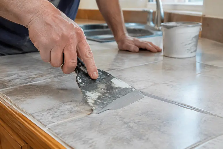 Application de l'enduit de lissage époxy sur les joints du plan de travail carrelé